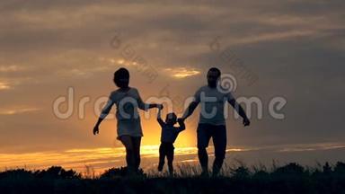 幸福<strong>的一家人</strong>在日落时在田野里奔跑。 夏夜<strong>一家人的</strong>剪影。 爱家庭<strong>的</strong>概念